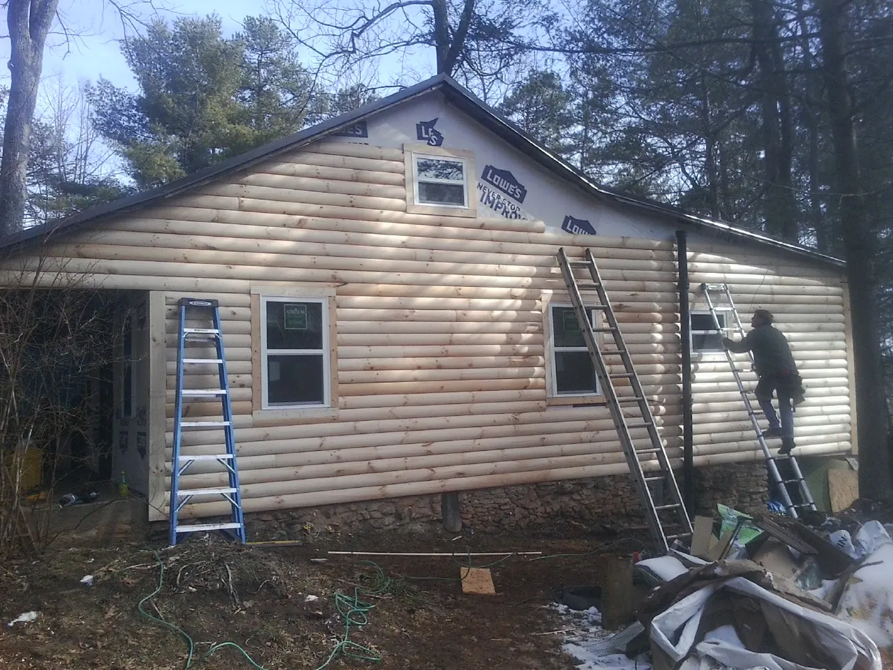 Ladders set against fresh log siding during an exterior remodel in Shawnee