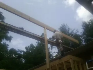 Carpenter setting a ridge beam over a new addition frame — Ice Dam Removal by Roofing Brothers in Shawnee