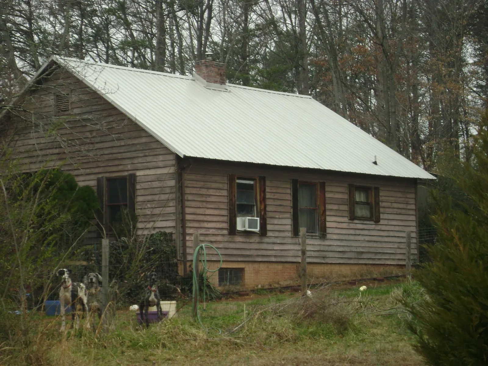 White metal roof on an old wood sided farmhouse, from a Asphalt Shingle Roof Repair job in Shawnee
